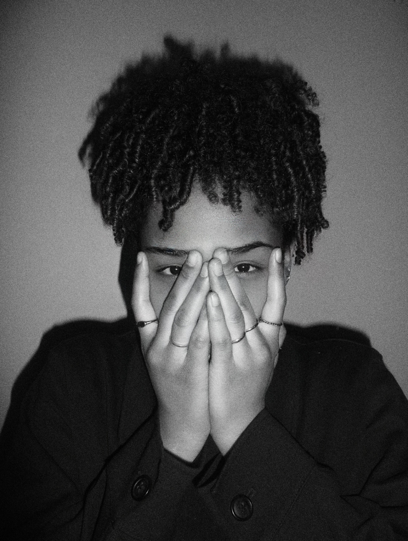 Aliana White holding her hands in front of her face, looking into the camera